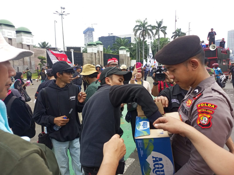 Aksi Simpatik, Polisi Bagikan Air Mineral dan Roti kepada Buruh di Depan DPR/MPR
